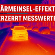 Thermografie-Aufnahme einer Stadtstraße mit Autos und Gebäuden, zeigt den Wärmeinsel-Effekt mit klaren Temperaturunterschieden
